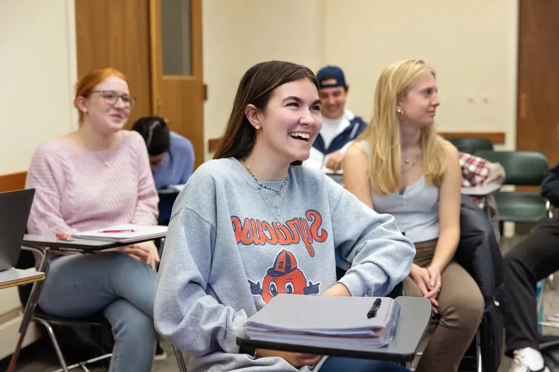 People smiling and sittting in class.